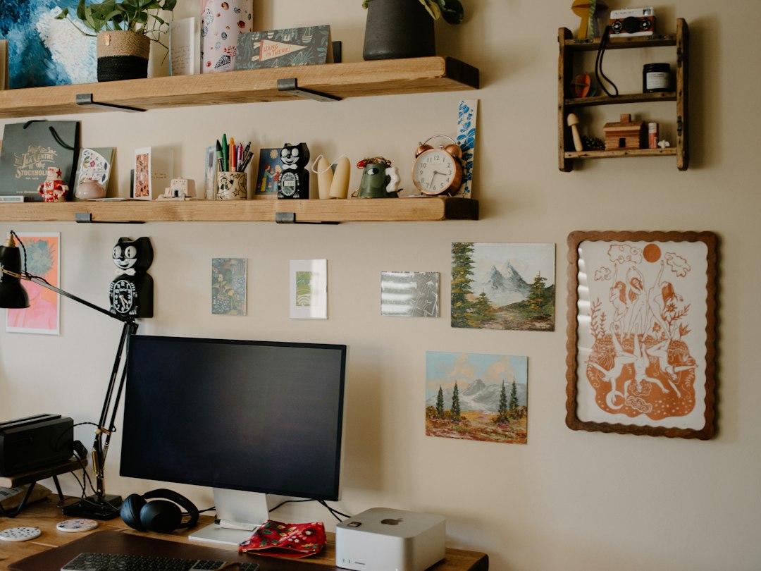 Desk with computer, shelves, and artwork on wall
