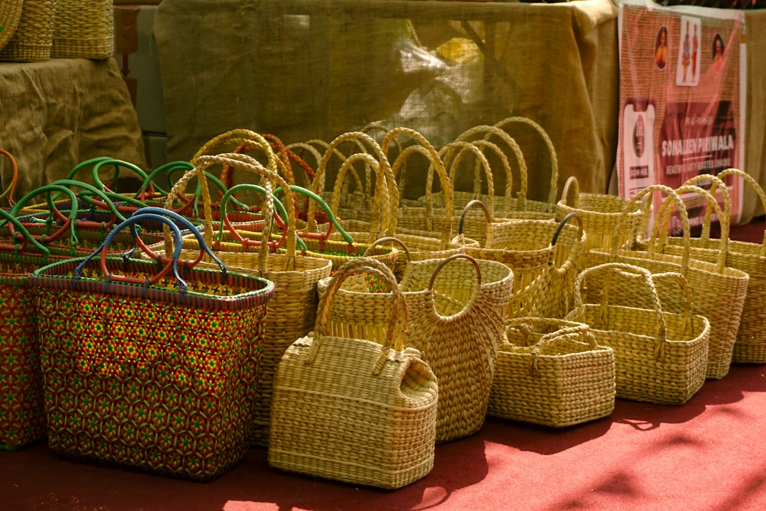 Woven straw baskets with colorful handles displayed